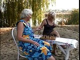 Long haired blond slut fingers grandma on the bench